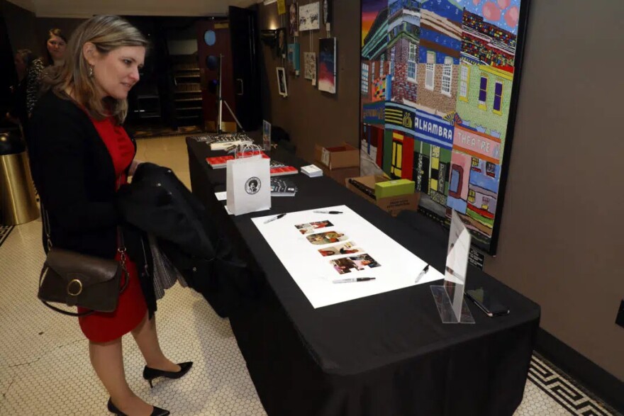 Carol Easterly looks at family photos of Gloria Jean Watkins, who wrote under the pen name bell hooks, during a Celebration of Life for Watkins on Saturday, April 2, 2022, at the Alhambra Theatre in Hopkinsville. Easterly, the museum programs coordinator for the Kentucky Historical Society, was one among many guests who traveled from across Kentucky to attend the service.