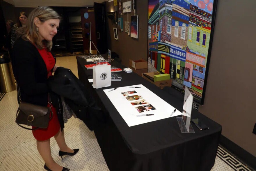 Carol Easterly looks at family photos of Gloria Jean Watkins, who wrote under the pen name bell hooks, during a Celebration of Life for Watkins on Saturday, April 2, 2022, at the Alhambra Theatre in Hopkinsville. Easterly, the museum programs coordinator for the Kentucky Historical Society, was one among many guests who traveled from across Kentucky to attend the service.