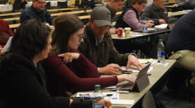 (Left to right) Kayla Holscher, Jenna Lansing and Andy Hruby work as a group during the Ag Survivor simulator activity at Purdue University's Top Farmer Conference.