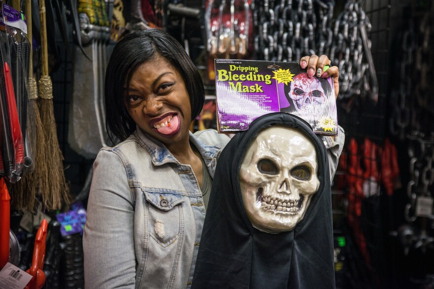 Marshia Miller grimaces as she holds up a costume that spurts out fake blood for her 12-year-old son.