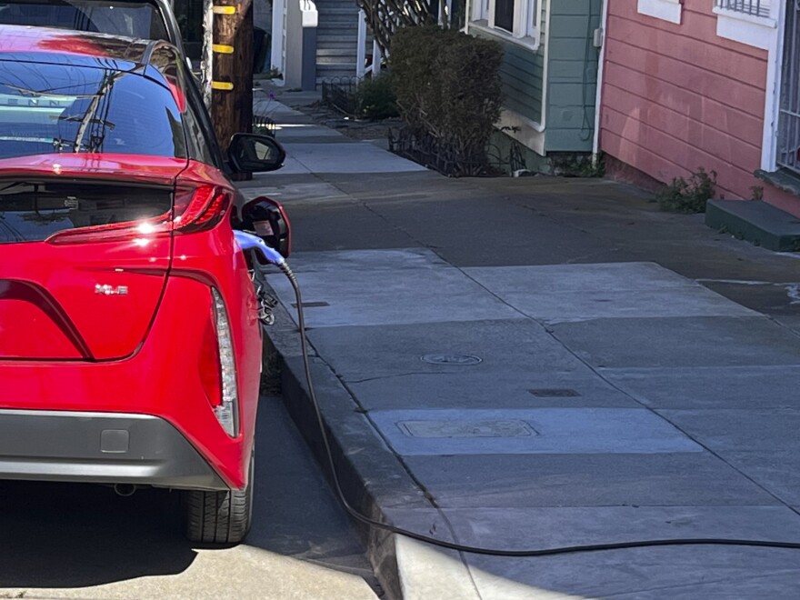 A charging cord for an electric vehicle is seen strung across a public sidewalk in San Francisco on Sept. 23.