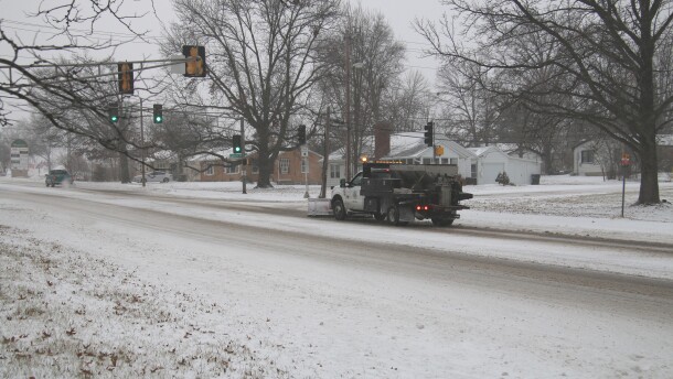 A snow plow makes its way through an intersection on West Broadway in Columbia.