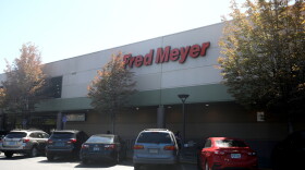 Cars parked in front of a grocery store called Fred Meyer.