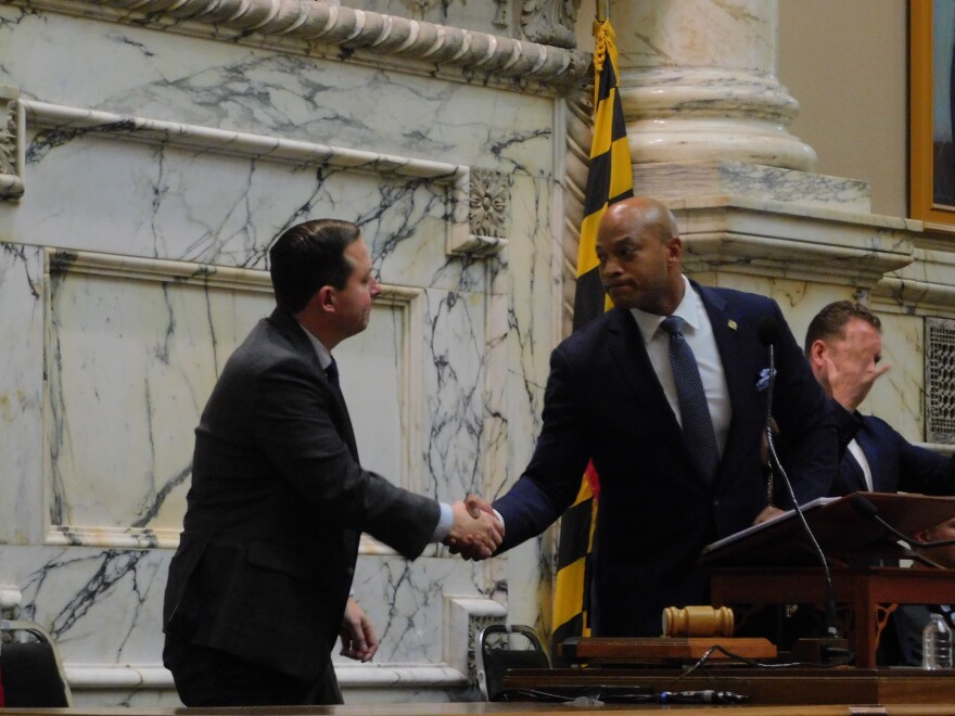 Gov. Wes Moore offers a hand shake to Senate President Bill Ferguson after commenting on their disagreement over early redistricting during his State of the State address on Wednesday in the House Chamber in Annapolis, Md.
