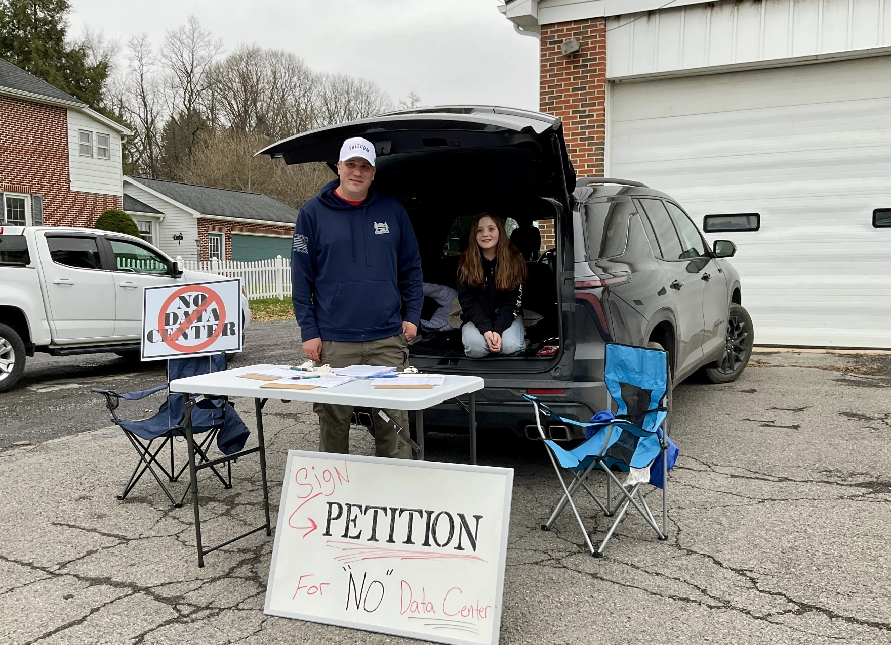 Jared Welch and his daughter, Valary, outside the building where PNK Group was holding an open house about the data center it wants to build in Gregg Township, Union County. (Anne Danahy/WPSU)