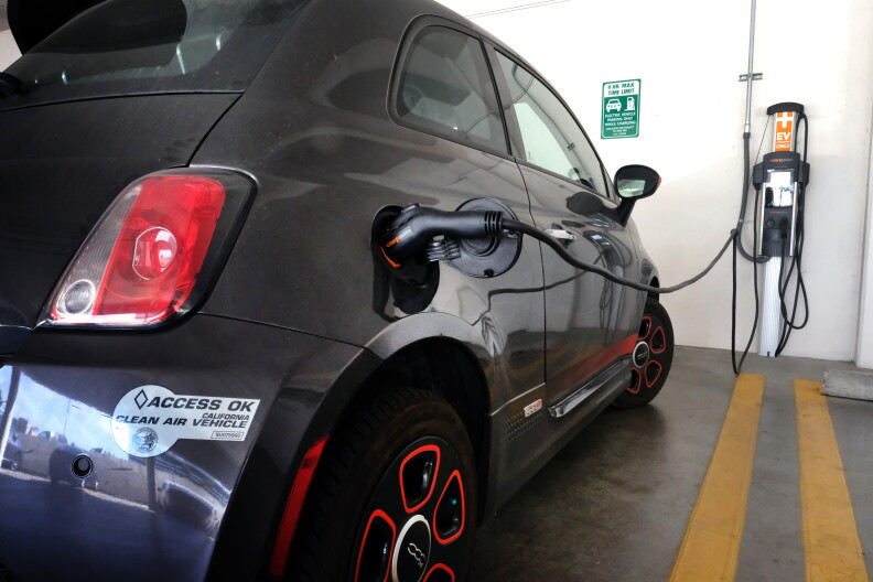  A black electric vehicle charges. 