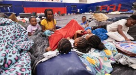 The grandchildren and great grandchildren of Vera Kelly, of Tallahassee, sit together after evacuating to a hurricane shelter at Fairview Middle School, ahead of Hurricane Helene, expected to make landfall here today, in Leon County, Fla., Thursday, Sept. 26, 2024. (AP Photo/Gerald Herbert)