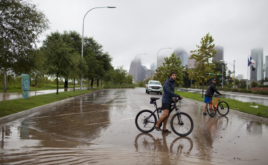 Houston residents Julian Fernandez (left) and Simon Loscertales survey the flooding next to Buffalo Bayou Park in Houston. "I am now a refugee," says Fernandez, whose neighborhood has flooded.