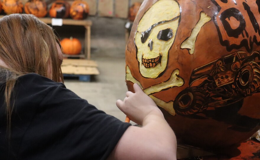 Artist Rylee Gordon carving a monster truck-themed jack-o-lantern