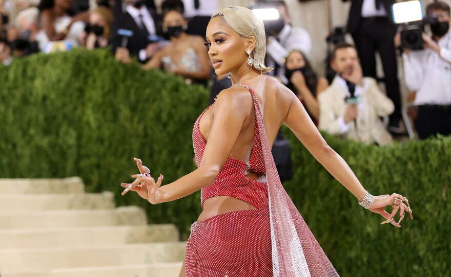 Saweetie told red carpet host Keke Palmer that her Christian Cowan caped dress is inspired by the Black American heritage flag and the Filipino flag.