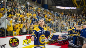 Senior defenseman Jayden Lee cheers back to the crowd as he enters the rink, joining his teammates as they celebrate Quinnipiac's first NCAA Hockey Championship.