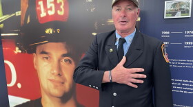 Retired New York City firefighter Tom Pair stands next to a photo of Firefighter Stephen Siller, who was killed in the World Trade Center South Tower on Sept. 11, 2001 while trying to rescue people.