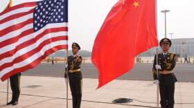 Members of the military honor guard hold American and Chinese flags before President Donald Trump is greeted by Chinese President Xi Jinping at a welcome ceremony at the Great Hall of the People, Thursday, May 14, 2026, in Beijing. (AP Photo/Mark Schiefelbein)