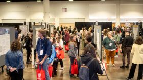 Attendees mingle during a poster show happy hour where anthropologists present their research and work in the main exhibit hall of the conference.