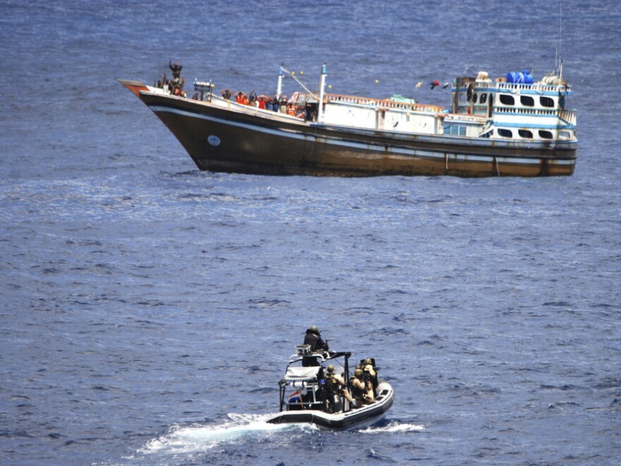 In this photo released by the Dutch defense ministry, suspected pirates stand on deck with their hands raised as Dutch marines approach a hijacked Iranian fishing boat off the coast of Somalia on April 4.