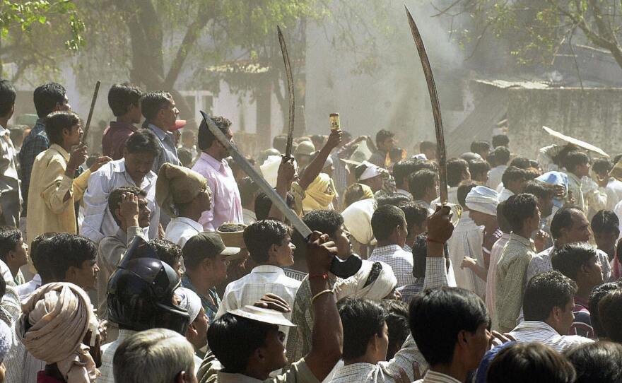 A Hindu mob waves swords at an opposing Muslim mob during communal riots in Ahmedabad in 2002.