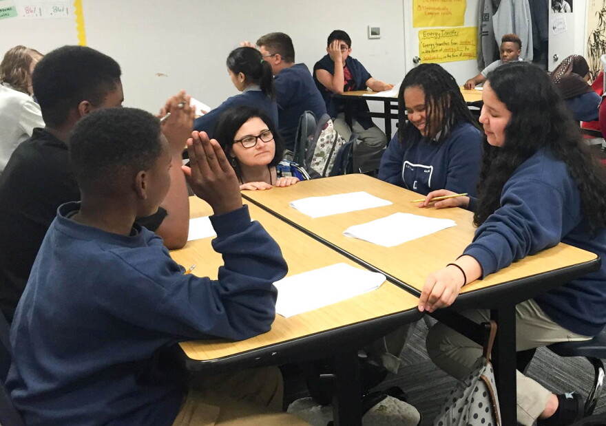 At Excel Public Charter School in Kent, Academic Intervention Specialist Mona Swanson works with students in a science class.
