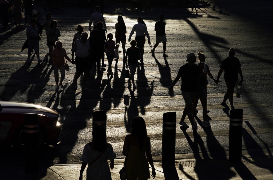 FILE - People cross Las Vegas Boulevard on July 2, 2021, in Las Vegas.