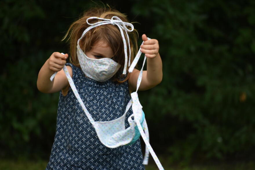 A child plays with a face mask.