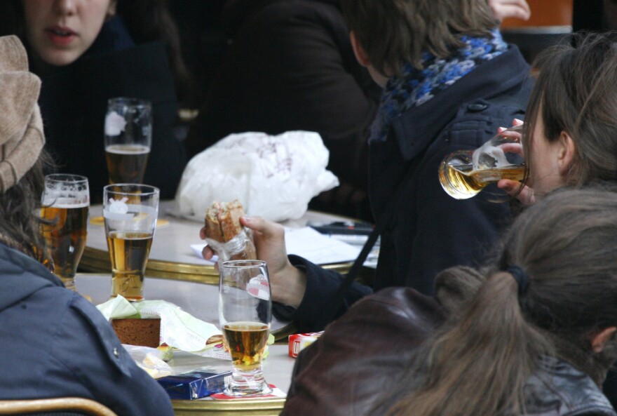 Youths drink beer in a Paris cafe.