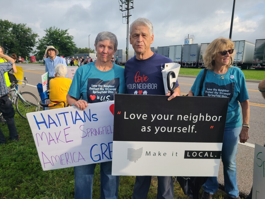 people stand with protest signs