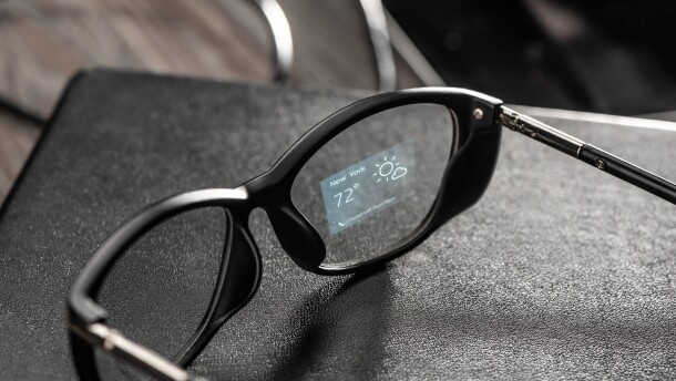 Weather app projected onto a lens of black smart glasses. Relevant information right in front of your eyes. Augmented reality with holographic technology concept.