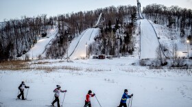 Cross-country skiers slide past the Suicide Hill Ski Bowl during an Ishpeming Ski Club practice in Ishpeming, Mich. on March 3, 2021. Many of those who ski jump also cross-country ski. The Olympic winter sport Nordic Combined integrates the two sports of ski jumping and cross-country skiing.