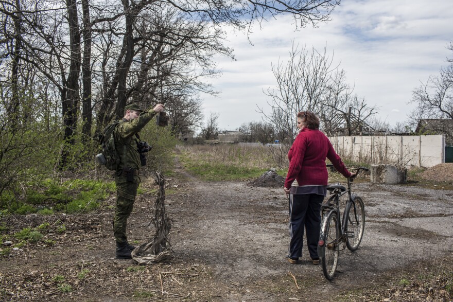 Lt. Mikhail Andronik, a soldier in the Donetsk People's Republic Army, shows an exploded artillery to Vera Anoshina, 52, a local resident.