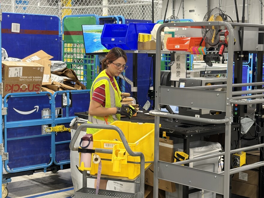 An unidentified employee at the Amazon delivery station in Yuma prepares an order.