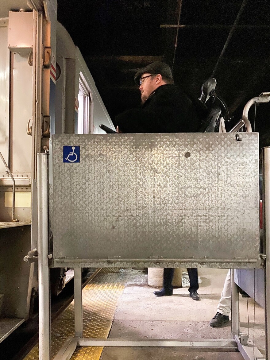 Adam Ballard, of the disability service and advocacy group Access Living, uses a wheelchair lift at Chicago's Union Station to board a train to Bloomington-Normal, to attend a statewide disability conference.