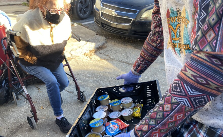 Meghan Memos selects snacks while waiting for her number to be called. Volunteers also distributed warm clothing, tea and coffee due to the cold weather. (Nicolette De Value/WUFT News)
