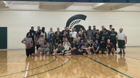 Special Olympics MSU participants, volunteers, and referees pose for a group photo at their final basketball game of the season.