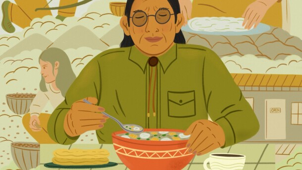 An Indigenous man eats a bowl of soup, surrounded by members of his community sourcing food and cooking it