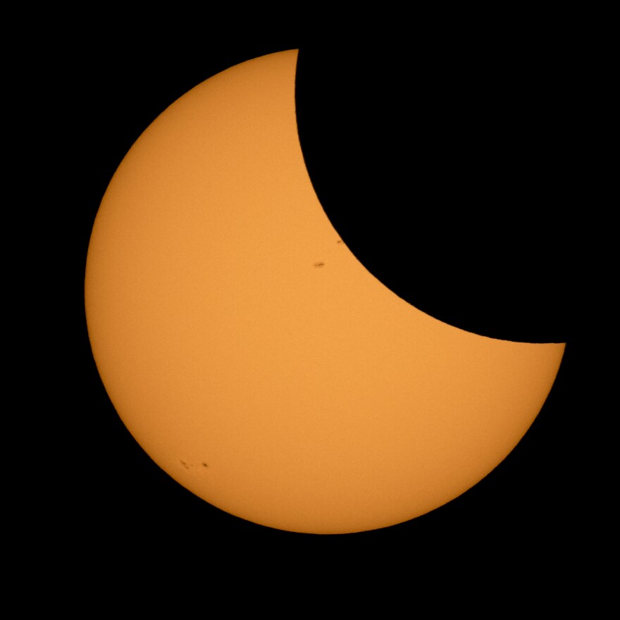 The moon is seen as it starts passing in front of the sun during a solar eclipse from Ross Lake, Northern Cascades National Park, in Washington on Monday, Aug. 21, 2017. (Bill Ingalls/NASA via AP)