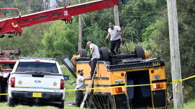 A vehicle recovery crew work to right an overturned school bus after a fatal collision, Monday, Oct. 5, 2026, in Winter Haven, Fla.