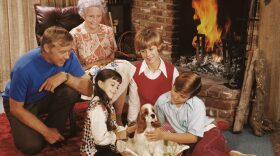 Two children with their parents, grandmother and a pet spaniel, circa 1975.