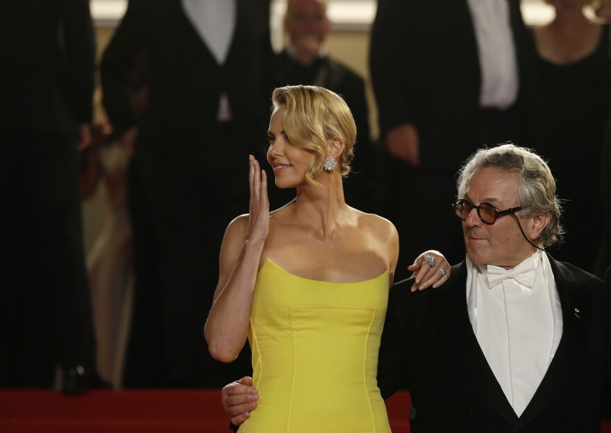 Actress Charlize Theron, left, and director George Miller leave after the screening of the film Mad Max: Fury Road at the 68th international film festival, Cannes, southern France, Thursday, May 14, 2015.
