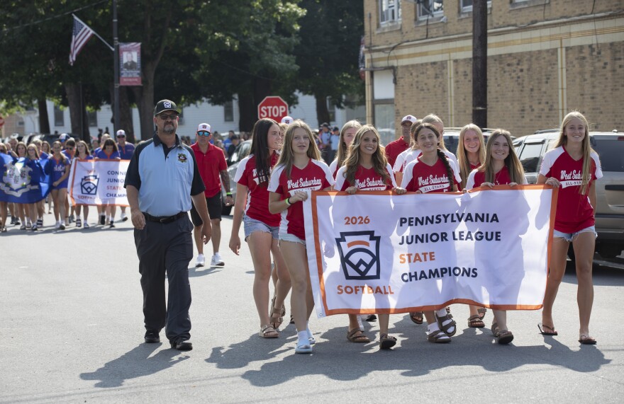 Members of the Pennsylvania Junior League Softball championship team, from West Suburban Little League in Johnstown, walk in the parade for the East Region Junior Little League Softball Championship in Nanticoke on Wednesday.