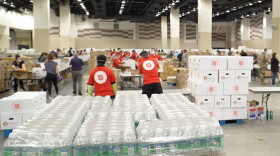 Volunteers from the Salvation Army, Midwest Food Bank, The Indiana National Guard and Lucas Oil Stadium pack food boxes.