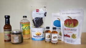 (l-r) Omnivore Vulcano Ginger Hot Sauce, Blackberry Farm Ramp Kraut, Pok Pok Som Thai Basil Drinking Vinegar, Neococoa Black Sesame Seed Brittle, Hummustir Hummus on Demand, Runamok Maple Syrups (Boubon Barrel-Aged and Cardamom Infused) and Superseedz Gourmet Pumpkin Seeds (Sea Salt and Super Spicy). (Jesse Costa/WBUR)