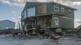 A green beach house ripped by a storm
