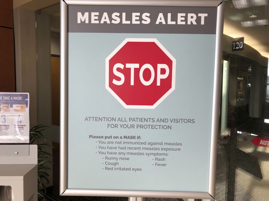 File - In this Jan. 30, 2019, file photo, a sign posted at The Vancouver Clinic in Vancouver, Wash., warns patients and visitors of a measles outbreak. The focus on measles in the Pacific Northwest intensified Friday, March 1, 2019, as public health officials in Oregon announced a new case of the highly contagious disease unrelated to an ongoing outbreak in Washington state that's sickened 68 people so far.