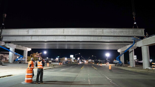 Crews watch the placement of concrete girders for the North South Corridor over Sprague Avenue.