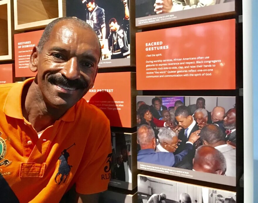 St. Louis American photojournalist Wiley Price poses by his photo “Message for the Messenger,” which depicts a group of AME bishops praying over then-U.S. Senator Barack Obama, in the Smithsonian Museum of African American History.