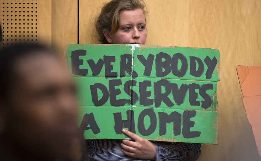 Julia Reed holds a sign during the public hearing on Wednesday, November 1, 2017, at City Hall in Seattle. 