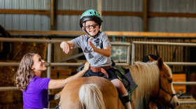 Elizabeth Nielsen works with one of her clients on a horse at Tiny Voice.