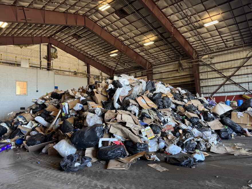 a trash pile with cardboard boxes and black plastic bags