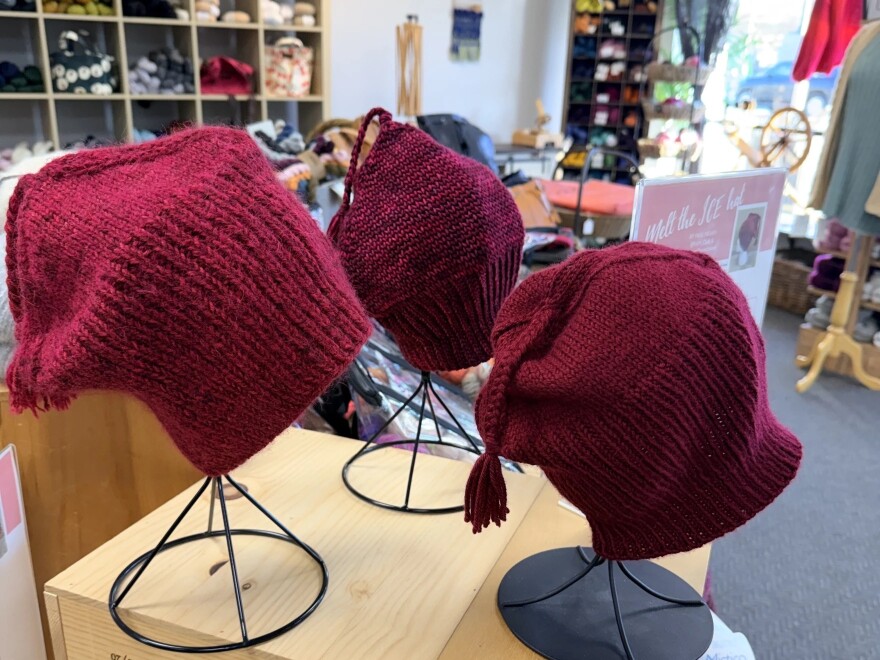 Handmade red "Melt the ICE" hats are on display at Minneapolis yarn store Needle & Skein.