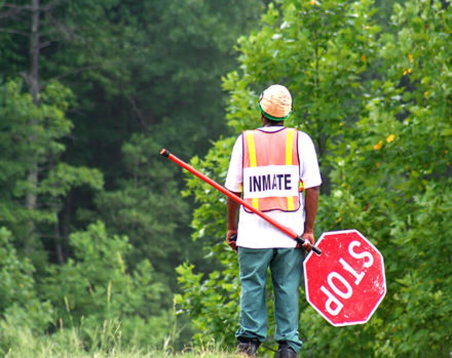 An inmate in a work crew stands on the side of a road. Tuesday was the second day of a federal trial over a 2018 Florida law requiring felons to pay off their fines and penalties.