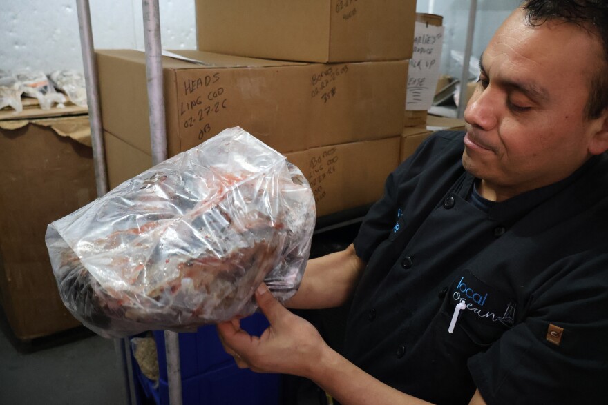Local Ocean sous chef Enrique Garcia holds a bag of fish heads destined for the restaurant's 100% Fish program. The heads will be converted into usable products.